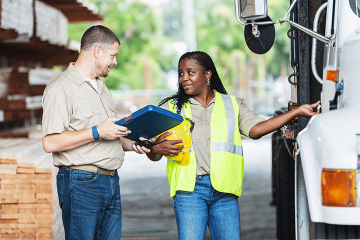 Trucking company employees inspect a semi truck