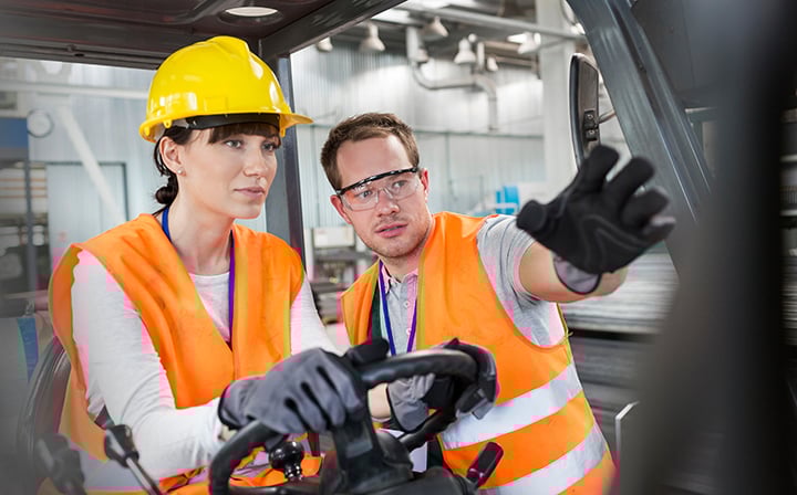 person on a forklift being trained in a warehouse