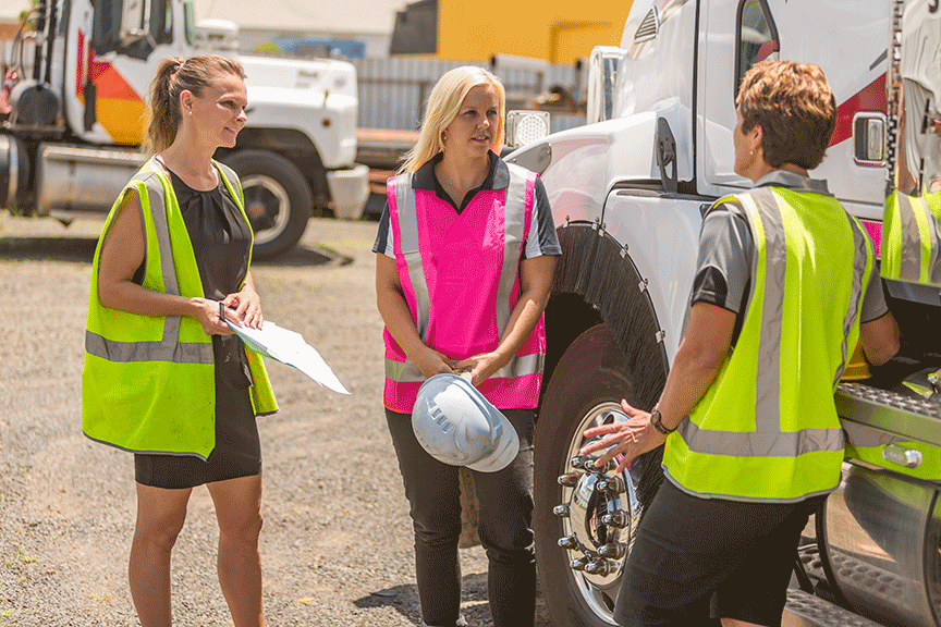 Trucking company employees inspect a semi truck